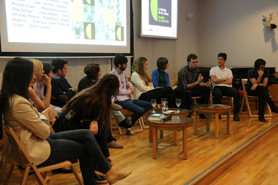 Grupo de personas sentadas con pantalla al fondo